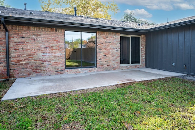 rear view of house featuring a lawn and a patio