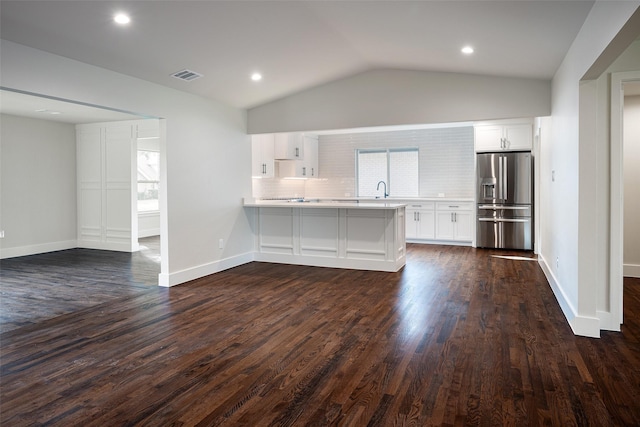 unfurnished living room featuring dark hardwood / wood-style floors, sink, and vaulted ceiling