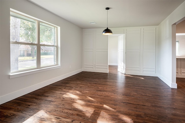 unfurnished dining area featuring dark wood-type flooring