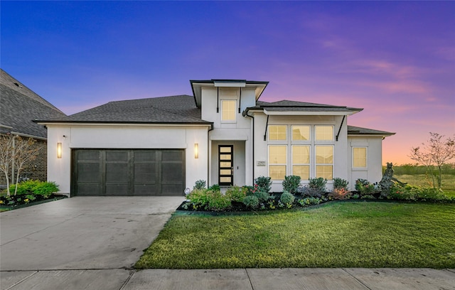 contemporary home featuring a lawn and a garage