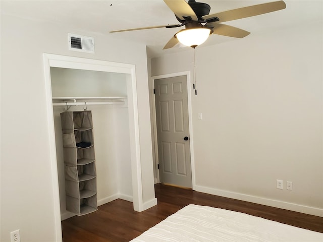 unfurnished bedroom featuring ceiling fan, dark wood-type flooring, and a closet