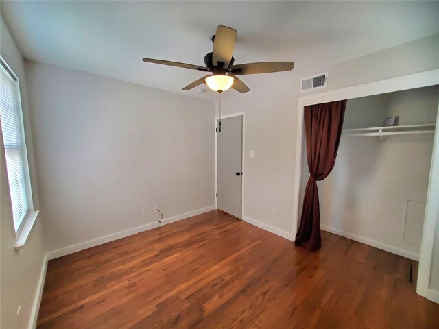 unfurnished bedroom featuring ceiling fan, dark hardwood / wood-style flooring, and a closet