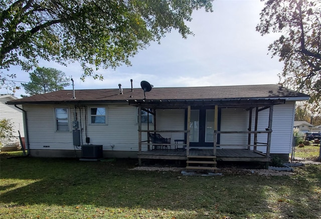 back of property with a yard and central air condition unit