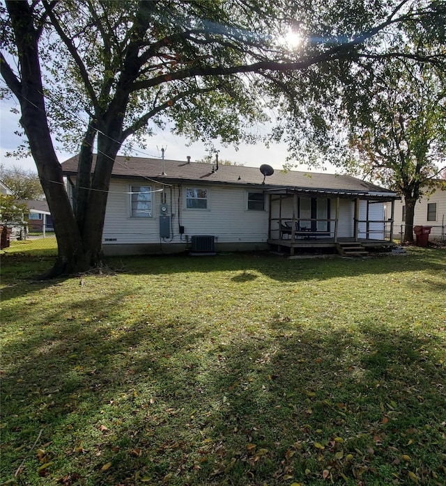 rear view of house featuring a lawn and cooling unit