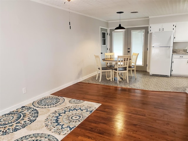 dining area featuring ornamental molding and dark hardwood / wood-style flooring