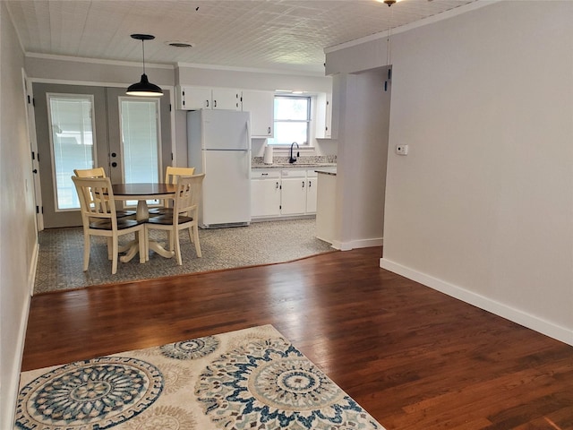 dining area with ornamental molding, sink, dark hardwood / wood-style floors, and french doors