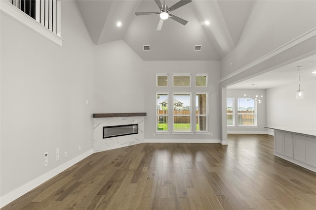 1347 Overton St, Frisco, TX 75036 - unfurnished living room featuring high vaulted ceiling, a premium fireplace, ceiling fan, wood finished floors, and a chandelier