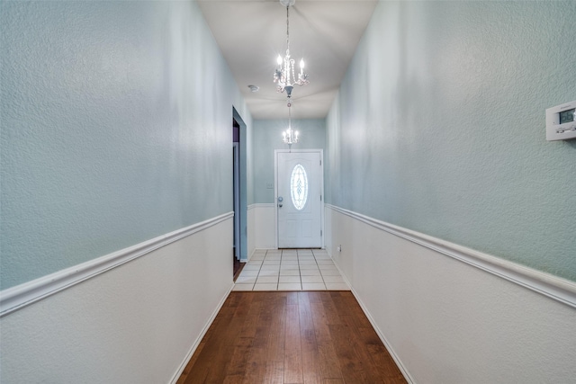 doorway to outside featuring an inviting chandelier and light wood-type flooring