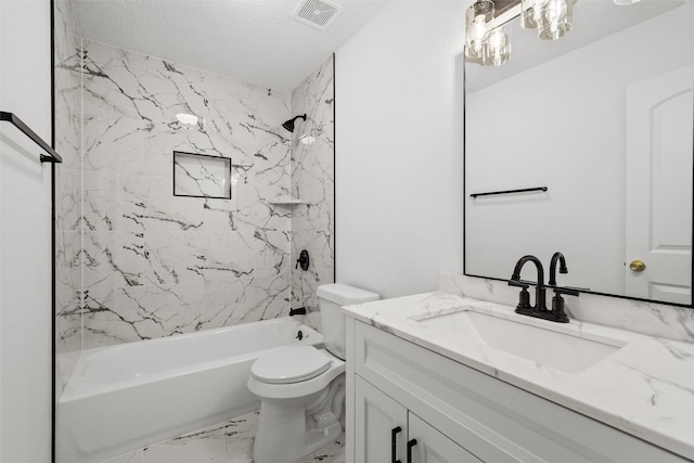 full bathroom featuring a textured ceiling, vanity, toilet, and tiled shower / bath