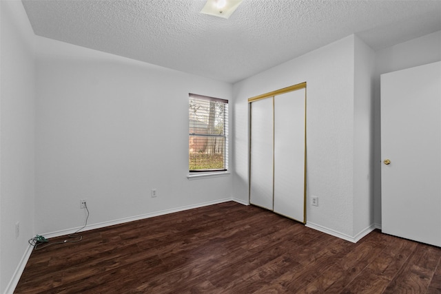 unfurnished bedroom with a closet, dark hardwood / wood-style flooring, and a textured ceiling