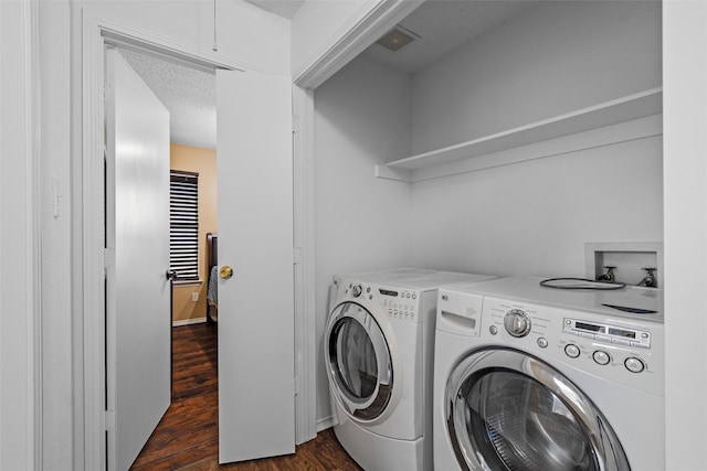 laundry room featuring dark hardwood / wood-style flooring, washer and dryer, and a textured ceiling