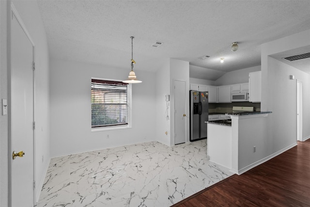 kitchen with light wood-type flooring, white appliances, a textured ceiling, white cabinets, and hanging light fixtures