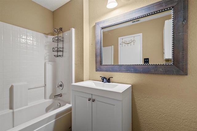 bathroom with vanity, shower / bath combination, and a textured ceiling