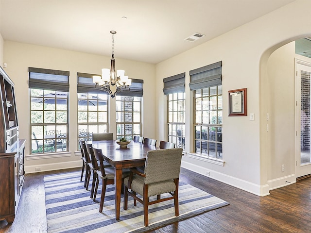 dining space with dark hardwood / wood-style flooring and a chandelier