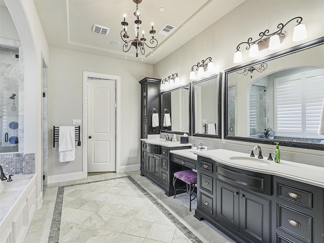 bathroom featuring vanity, a notable chandelier, and shower with separate bathtub