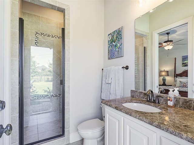 bathroom with vanity, ceiling fan, toilet, and a shower with shower door