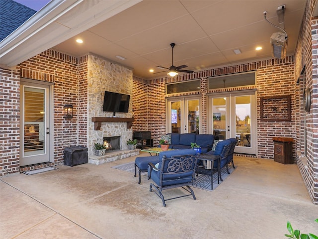 view of patio / terrace with an outdoor living space with a fireplace, french doors, and ceiling fan