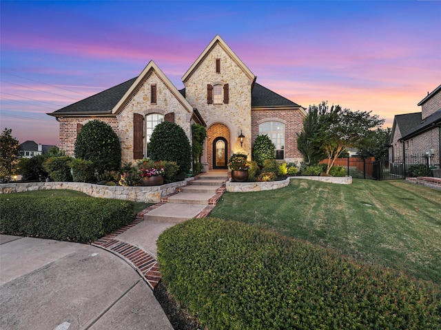 french country inspired facade with a lawn