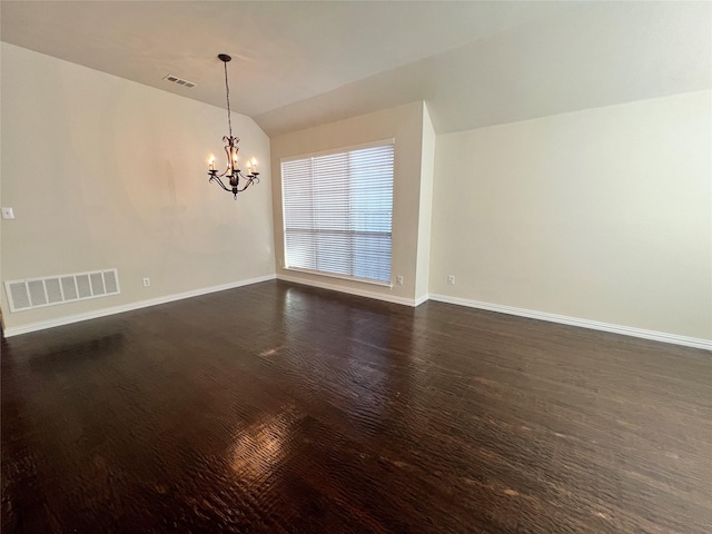 unfurnished room with dark hardwood / wood-style flooring, a chandelier, and lofted ceiling