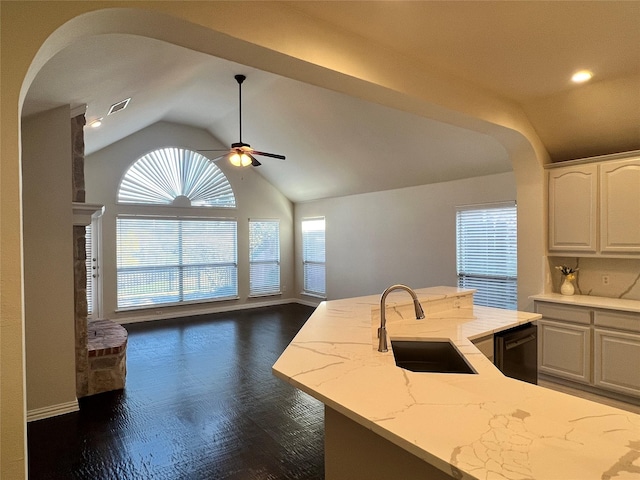 kitchen featuring light stone countertops, sink, dark hardwood / wood-style floors, lofted ceiling, and white cabinets