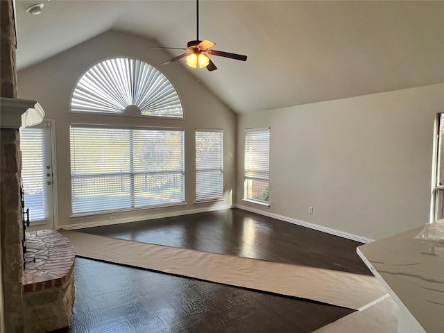 unfurnished living room with wood-type flooring, high vaulted ceiling, a brick fireplace, and ceiling fan