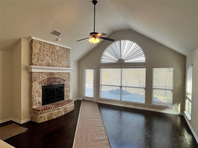 living room featuring a fireplace, vaulted ceiling, a wealth of natural light, and dark wood-type flooring