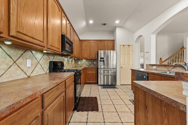 kitchen featuring backsplash, black appliances, sink, vaulted ceiling, and light tile patterned floors