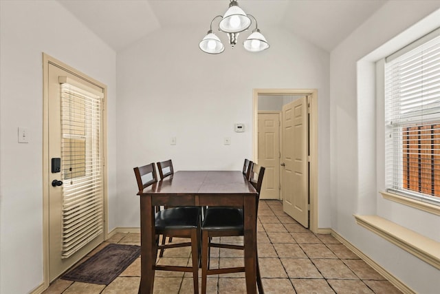 dining space with light tile patterned floors, lofted ceiling, and a notable chandelier