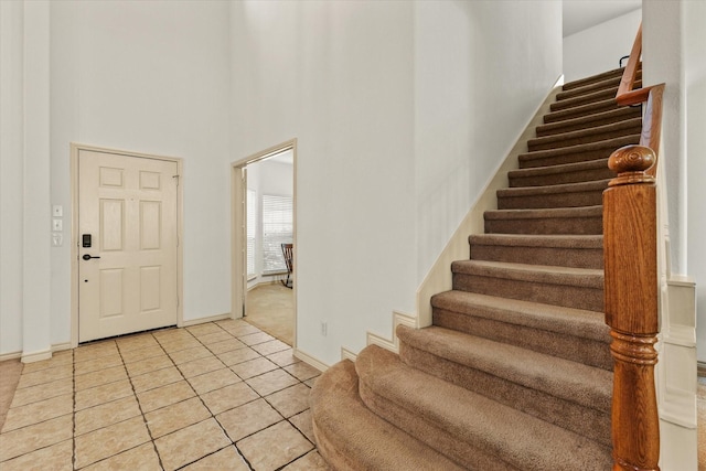 tiled entryway featuring a towering ceiling