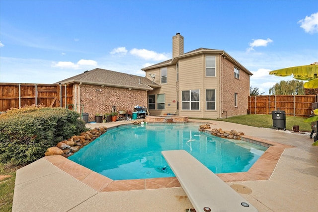 view of pool featuring a diving board and an in ground hot tub