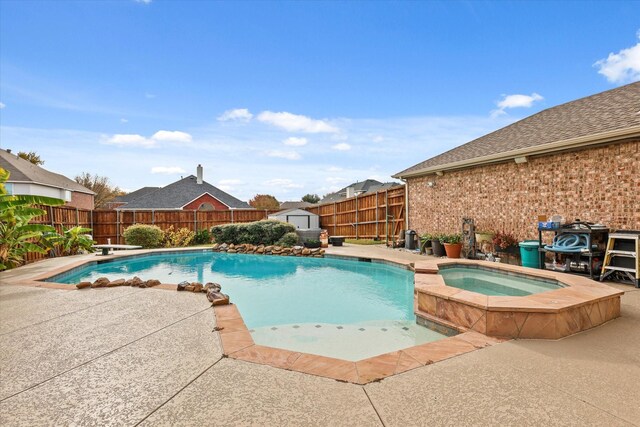 view of pool featuring an in ground hot tub, a diving board, and a storage shed