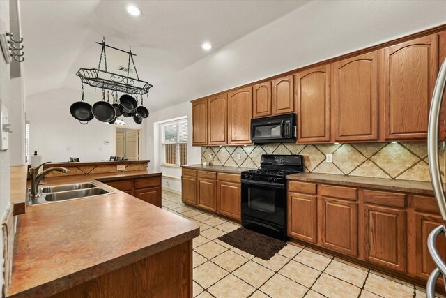 kitchen featuring lofted ceiling, black appliances, sink, decorative backsplash, and light tile patterned floors