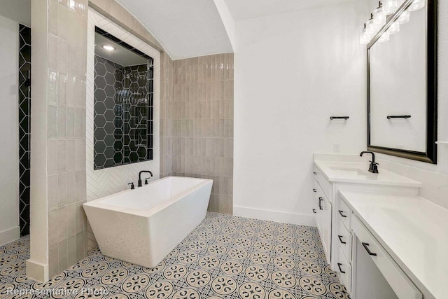 bathroom featuring tile patterned flooring, a tub to relax in, vanity, and tile walls