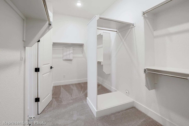 spacious closet with light colored carpet