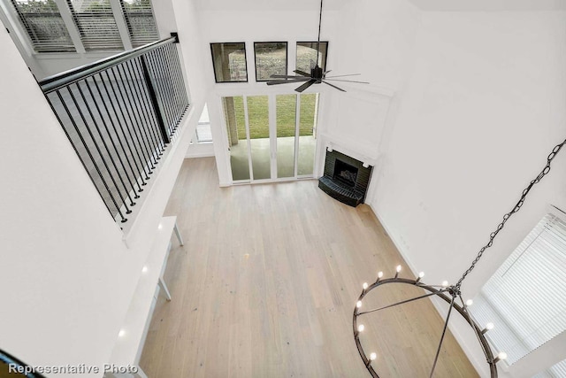 living room featuring ceiling fan, light hardwood / wood-style flooring, and a high ceiling