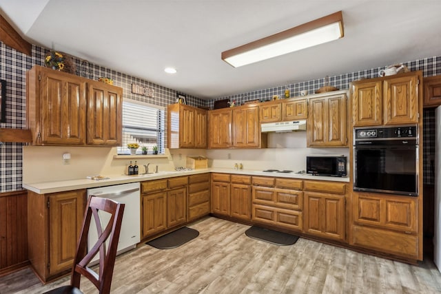 kitchen with sink, black appliances, and light wood-type flooring