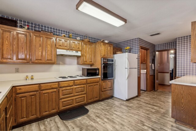 kitchen featuring black appliances and light wood-type flooring