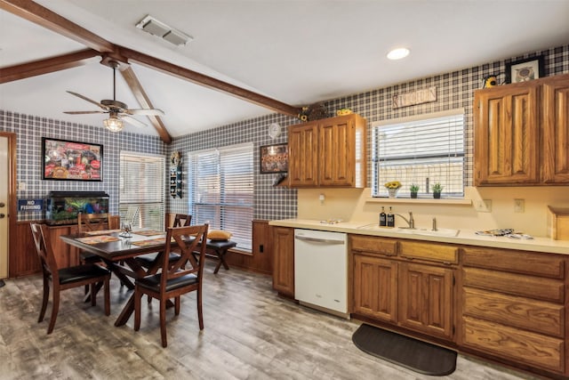 kitchen with ceiling fan, dishwasher, sink, vaulted ceiling with beams, and light hardwood / wood-style floors