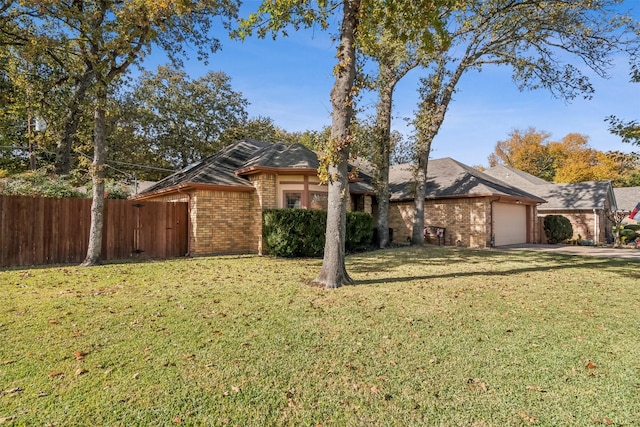 ranch-style house featuring a garage and a front lawn