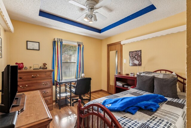 bedroom featuring a textured ceiling, light hardwood / wood-style floors, and ceiling fan