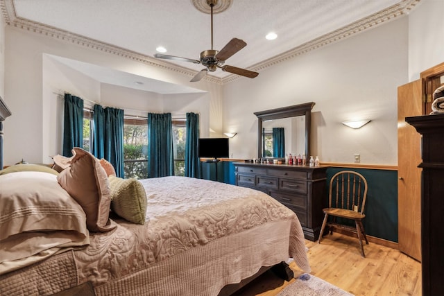 bedroom featuring ceiling fan, ornamental molding, and light wood-type flooring