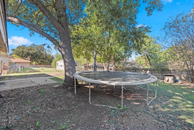 view of yard featuring a storage unit and a trampoline