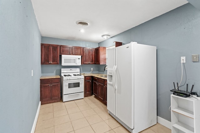 kitchen with light tile patterned flooring, white appliances, and sink