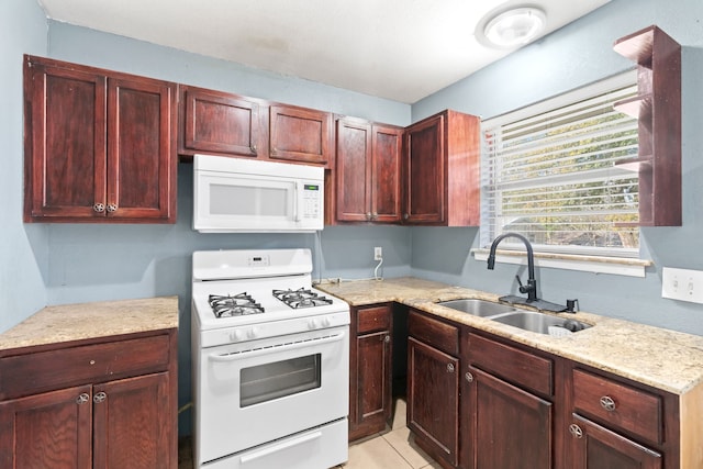 kitchen featuring sink, light tile patterned floors, and white appliances