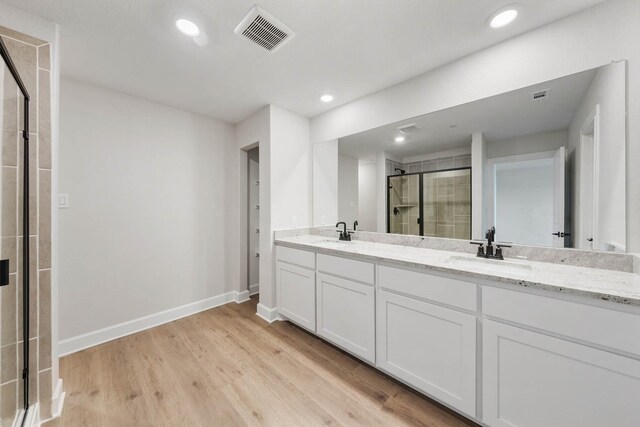 bathroom featuring vanity, hardwood / wood-style flooring, and walk in shower