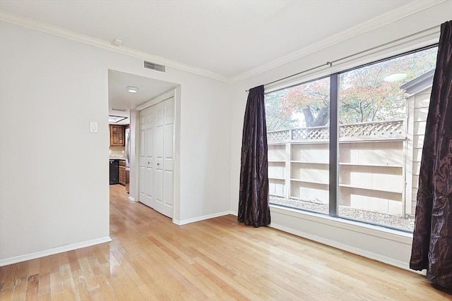 unfurnished room featuring ornamental molding and light wood-type flooring