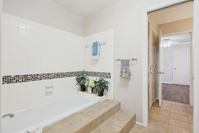 bathroom with wood-type flooring and tiled tub