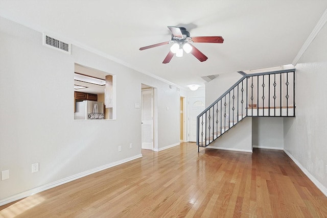 unfurnished living room with light wood-type flooring, ceiling fan, and ornamental molding