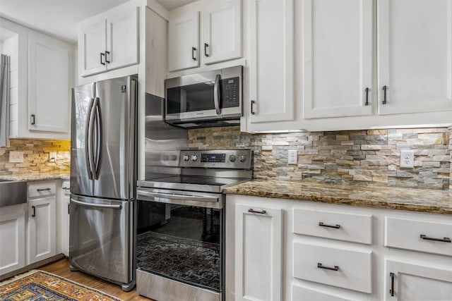 kitchen featuring dark wood-type flooring, decorative backsplash, stone countertops, white cabinetry, and stainless steel appliances