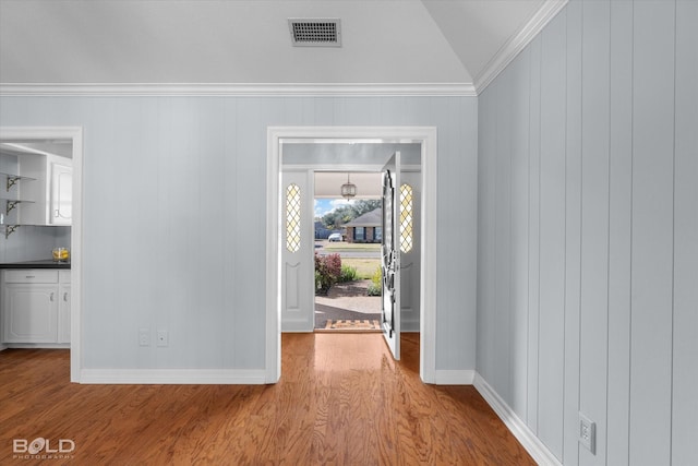 foyer featuring crown molding and light hardwood / wood-style floors